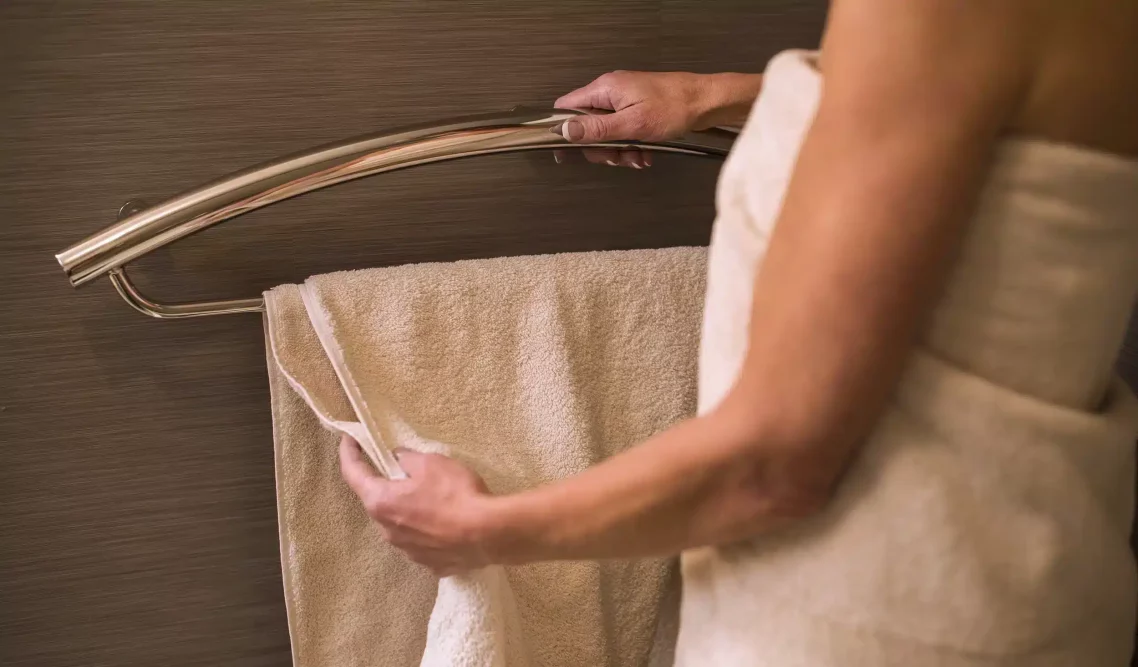 INVISIA towel bar grab bar installed on bathroom tile with bath towels