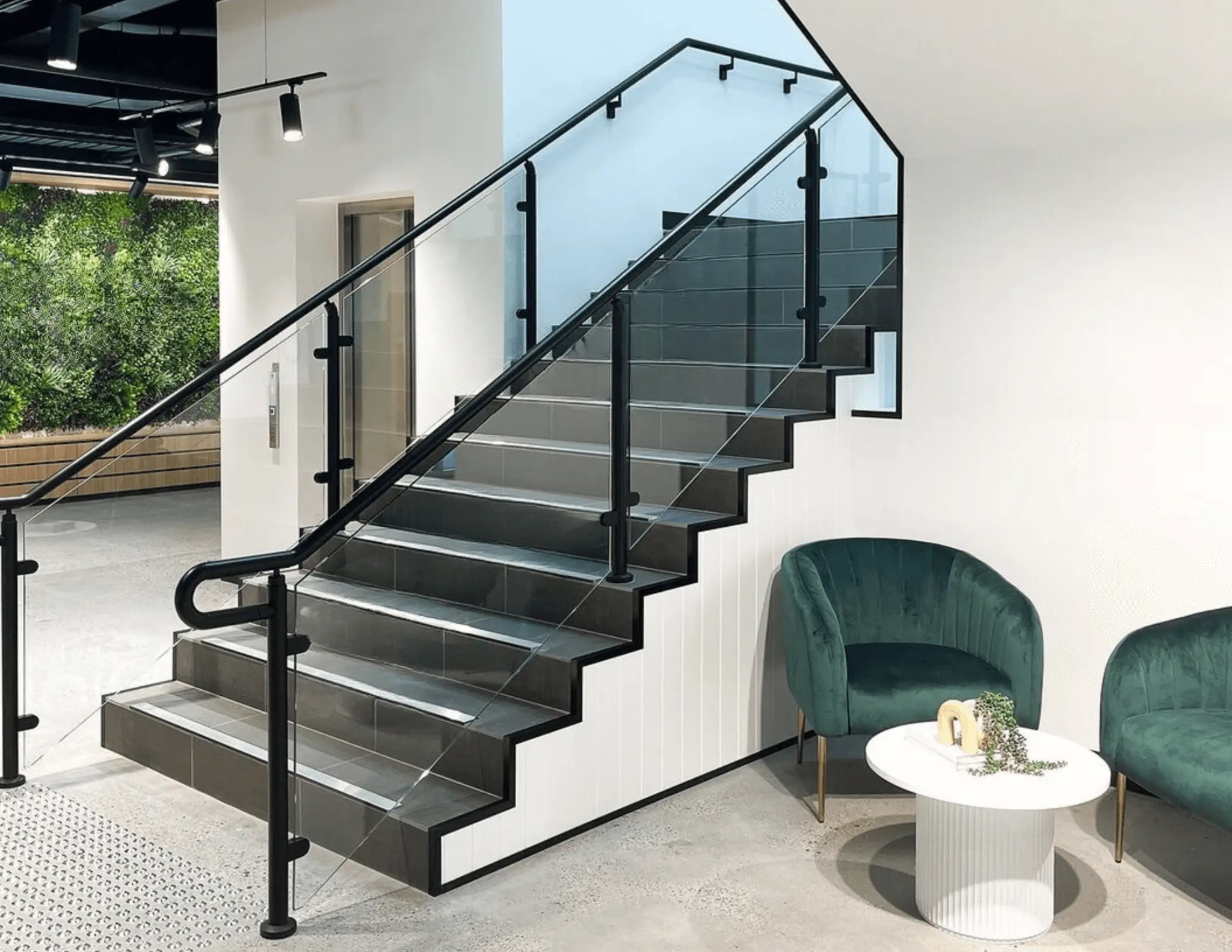 Promenaid black handrail on a modern staircase with glass balustrade
