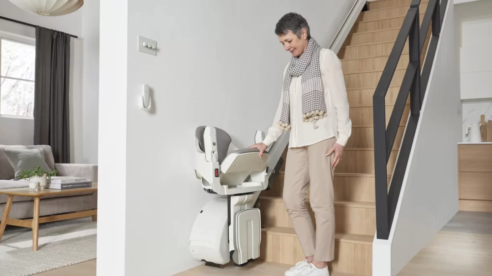 Access BDD HomeGlide stairlift with its seat being folded up at the bottom of the stairs