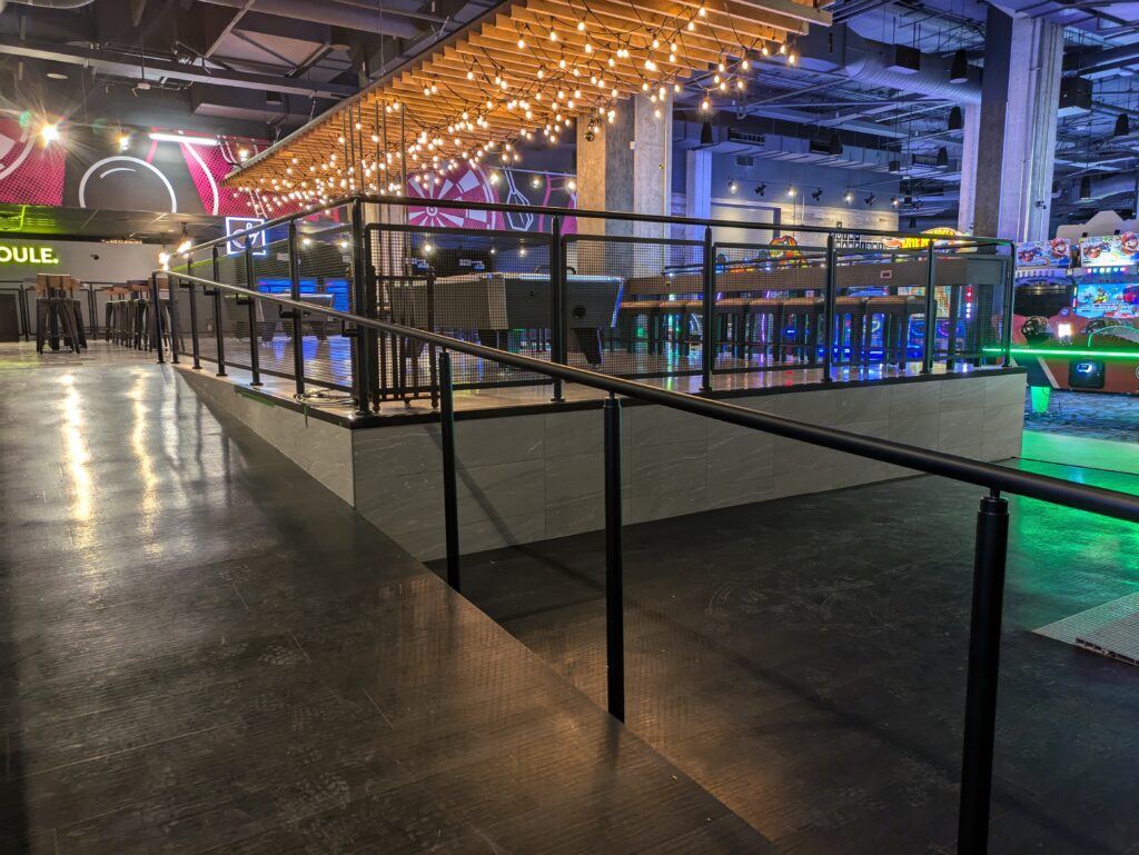 Promenaid railing along an access ramp in an indoor venue
