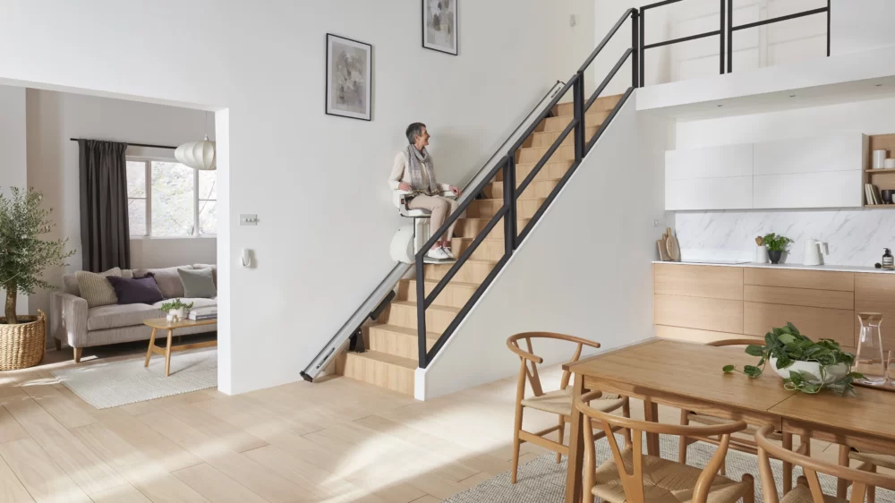 Access BDD HomeGlide straight indoor stairlift in motion on a residential staircase
