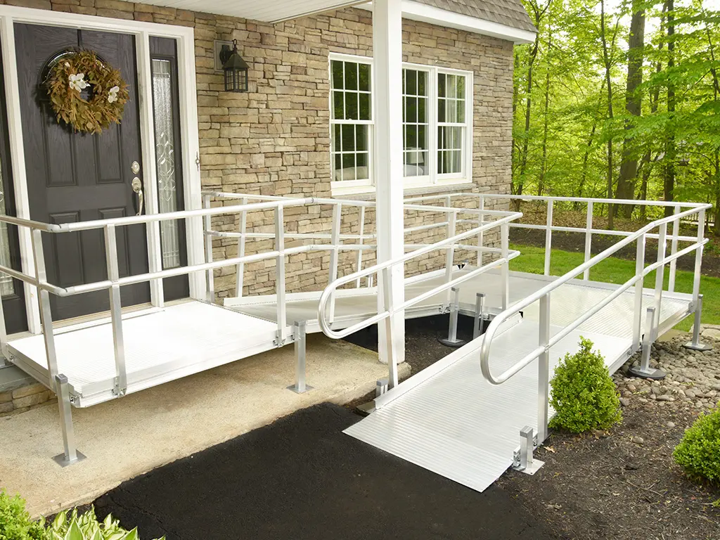 National Ramp aluminum ramp with handrails leading to an elevated home doorway
