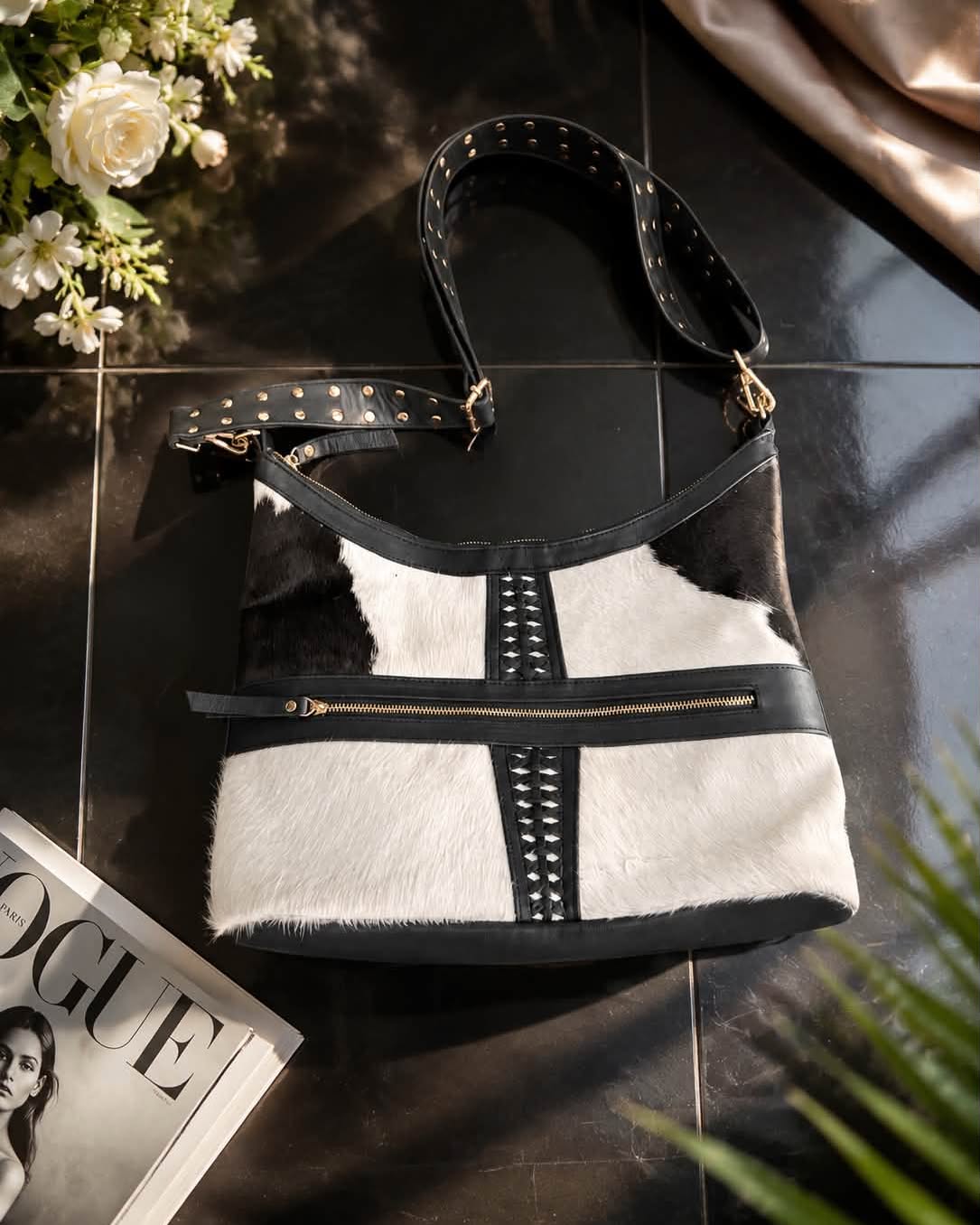 Handcrafted cow-fur bag with black leather trim and studded shoulder strap