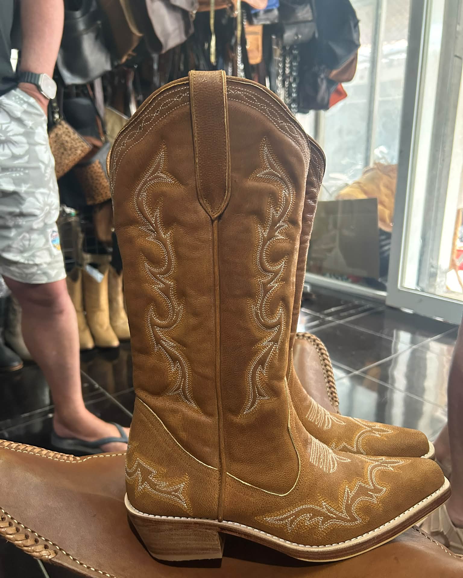 Brown pointed-toe cowboy boots with ornate pale Western stitching
